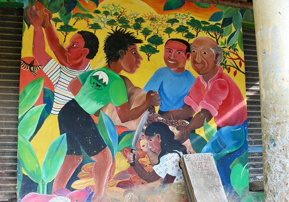 Un mural a un lado de la bodega en donde se almacena la producción de cacao representa el trabajo cooperativo de la Comunidad de Paz de San José de Apartadó. (Foto: Tracy L. Barnett)