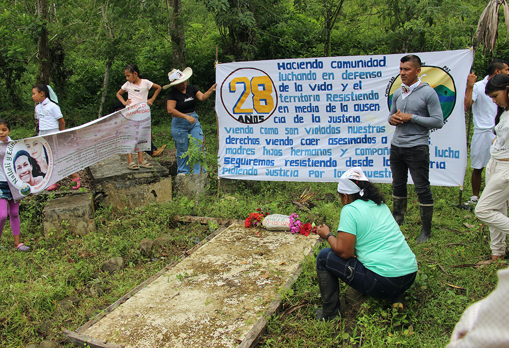 El líder comunitario Germán Gracianos (derecha) habla en la tumba de Édinson David el 23 de marzo de 2025. La Comunidad de Paz de San José de Apartadó, Colombia, inició la celebración de su 28.º aniversario con una peregrinación a las tumbas de dos miembros asesinados en 2024.  (Foto: Tracy L. Barnett)