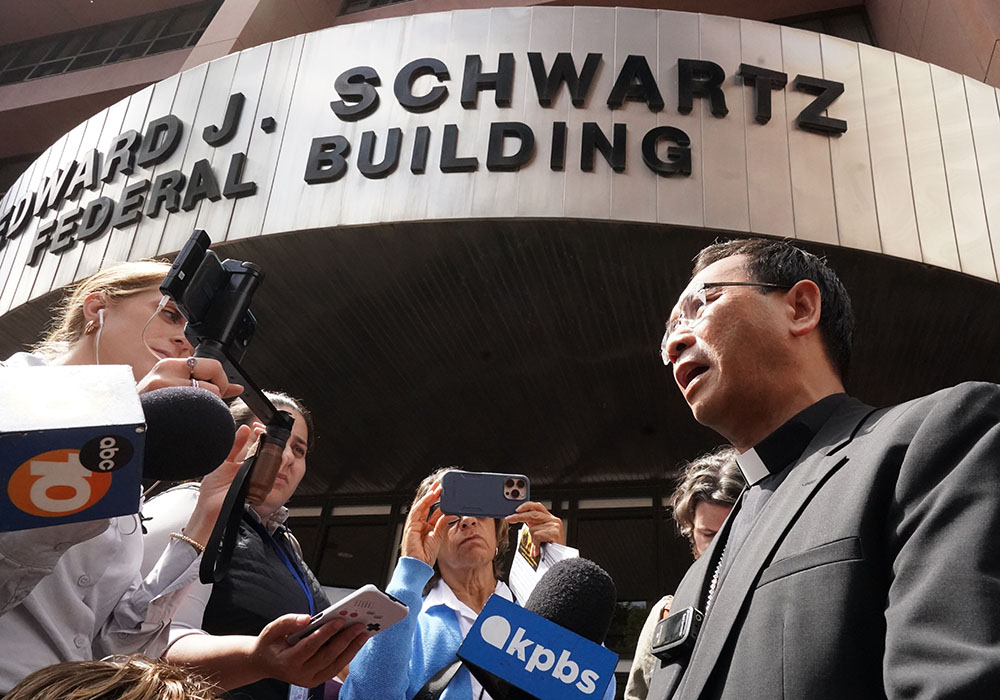 Bishop Michael Pham talks to reporters about his federal court visit to support immigrants at the Edward J. Schwartz Federal Building and U.S. Courthouse on World Refugee Day, June 20 in San Diego. (Chris Stone)