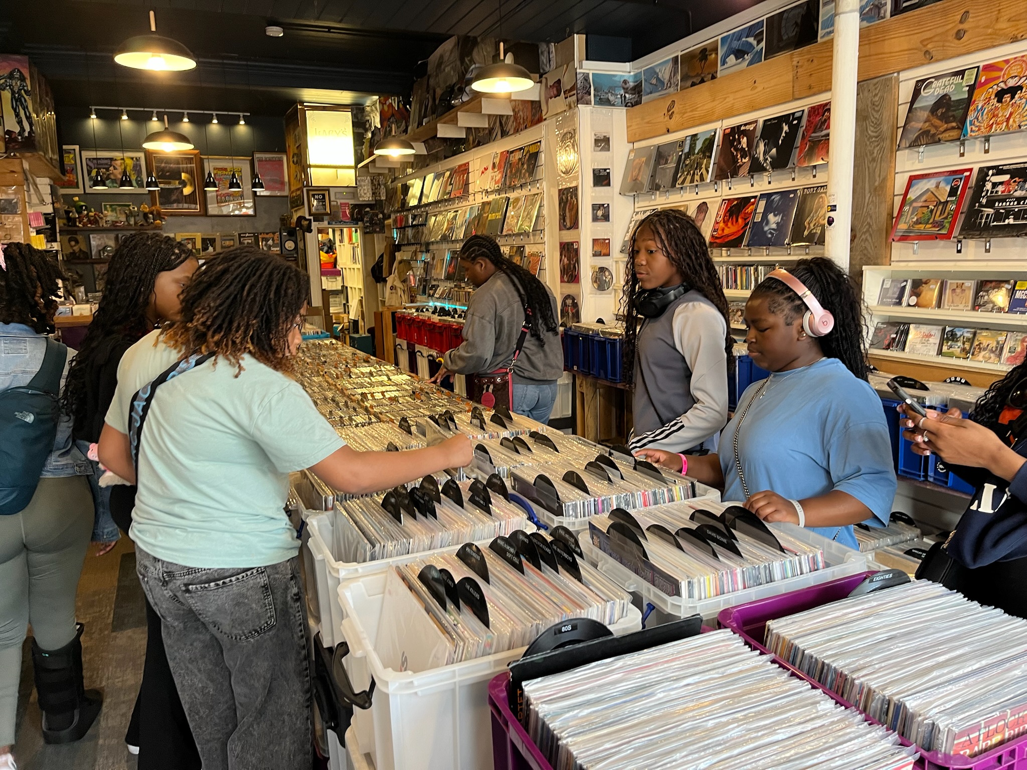 Gabriella Poindexter, Carleon Foma, and Trinity Hagans peruse the selection of records at Onion Vinyl, and independent shop in Felixstowe.