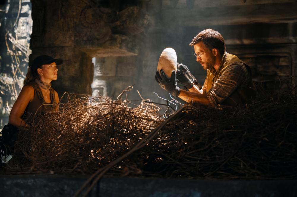 Scarlett Johansson looking at Jonathan Bailey holding an egg in "Jurassic World: Rebirth." (Universal Pictures)