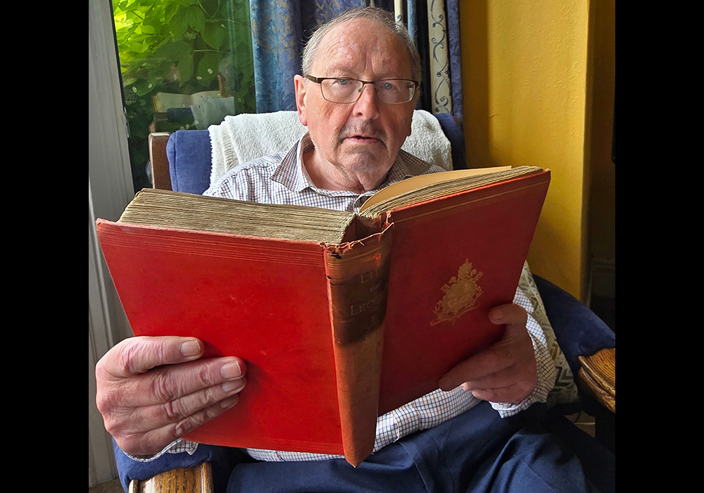 John Cooney, retired religious affairs correspondent with The Irish Times and Irish Independent, at his home in Dublin, Ireland, with his first edition, dating from 1887, of Life of Leo XIII: From an Authentic Memoir Furnished by His Order. (Sarah Mac Donald)