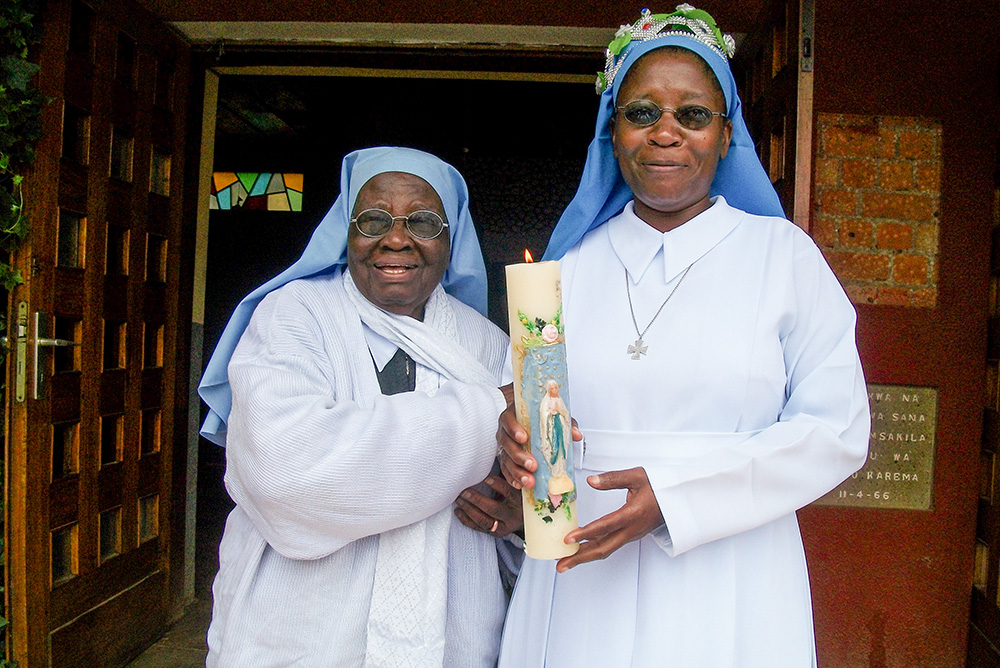Sr. Cecilia Namlamba, left, congratulates Sr. Editruda Mbegu on her silver jubilee at the Sumbawanga motherhouse of the Congregation of Our Lady Queen of Africa in Tanzania. Mbegu credits Namlamba as a friend who helped shape who she is today and who leads her closer to God. (Courtesy of Editruda Mbegu)