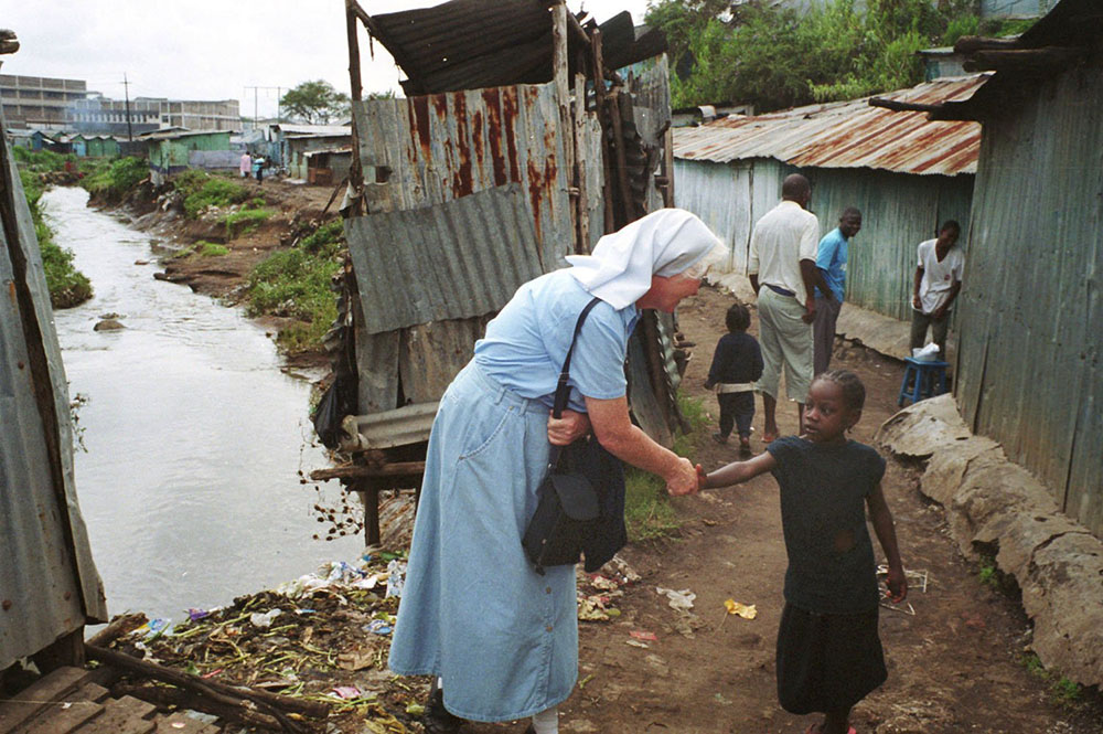 Mercy Sr. Mary Killeen greets a child in the South B slums in Nairobi, Kenya in this 2001 photo. (CNS/Declan Walsh) 