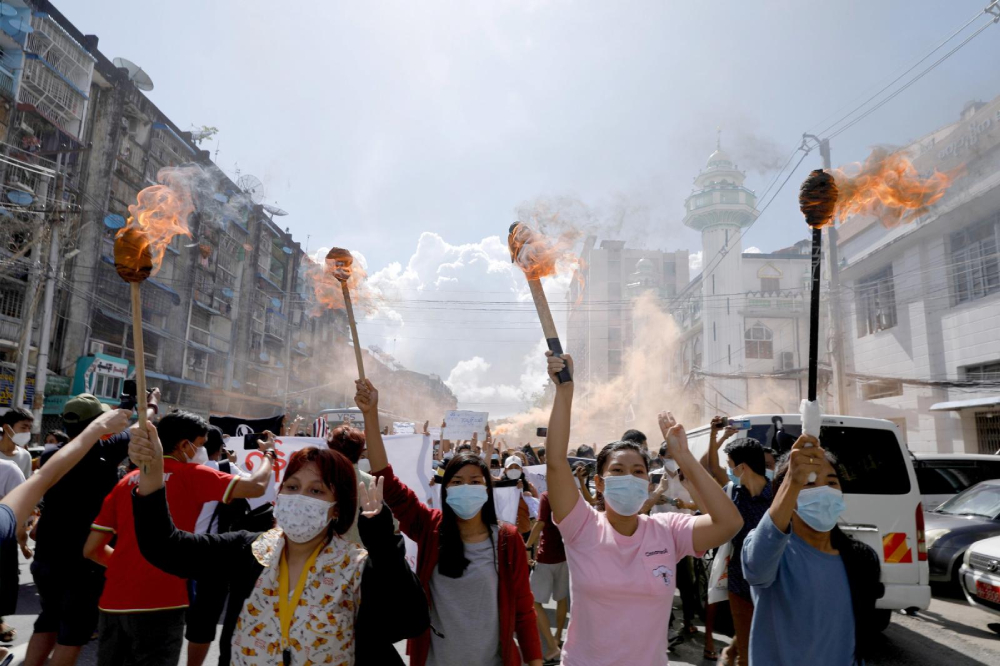 A group of women hold torches as they protest against the military coup in Yangon, Myanmar, July 14, 2021. People from all walks of life in Myanmar observed a "silent strike" in defiance of the ruling junta Feb. 1, 2022, the anniversary of the military coup. (CNS photo/Reuters)