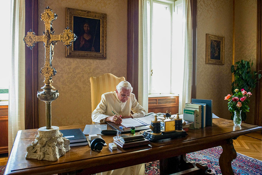 Pope Benedict XVI sits at his desk in the papal residence at Castel Gandolfo, Italy, in 2010. (CNS/Vatican Media)