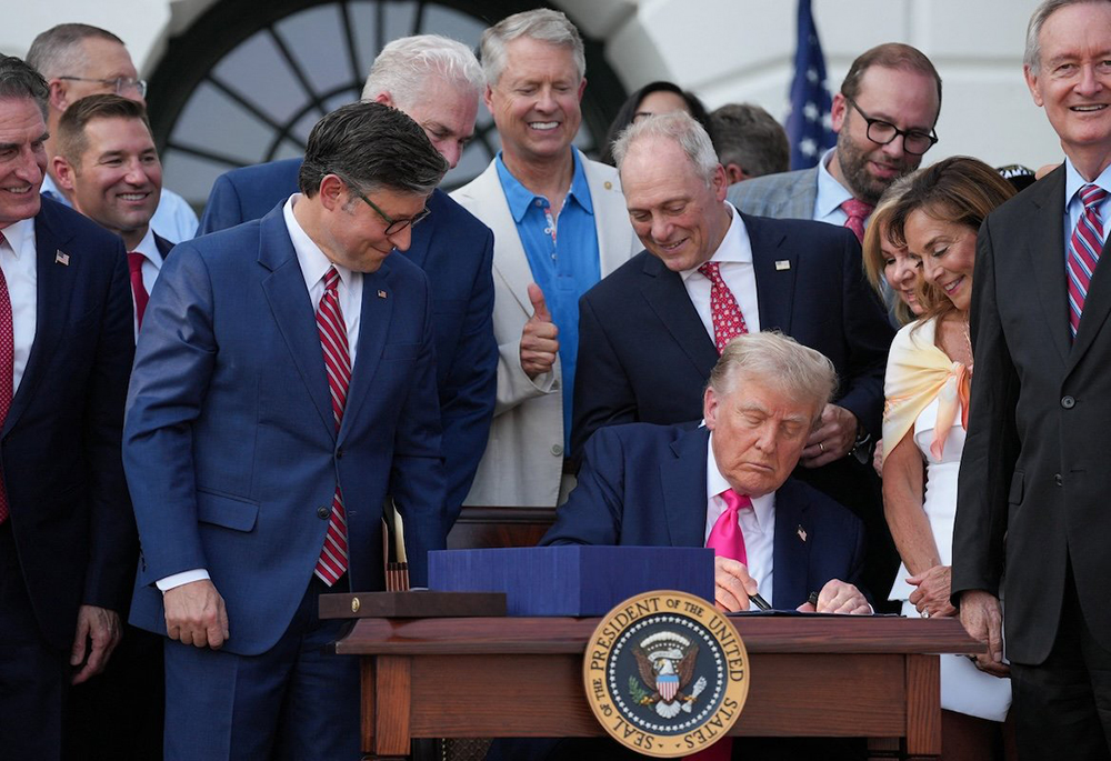 U.S. House of Representatives Speaker Mike Johnson looks at U.S. President Donald Trump signing the sweeping spending and tax legislation, known as the "One Big Beautiful Bill Act," to mark Independence Day, at the White House in Washington, on July 4, 2025. (OSV News/Reuters/Leah Millis)