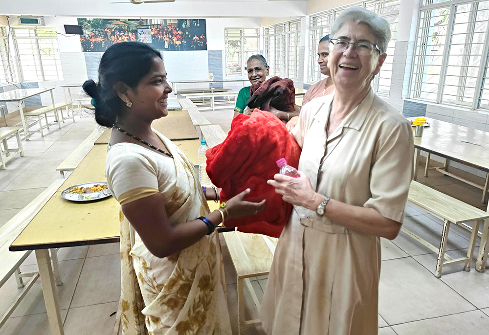 Franciscan Sisters of the Immaculate Sr. Maria Rosa giving a woolen blanket to a resident of Sumanahalli in Bengaluru, southern India (Thomas Scaria)