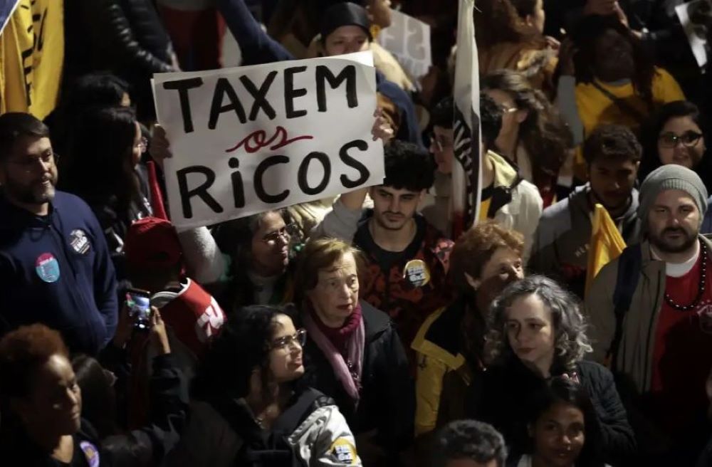 Protesters hold signs that say "tax the rich" during a demonstration in Sao Paulo, Brazil. Protesters hold signs that say "tax the rich" during a demonstration in Sao Paulo, Brazil.