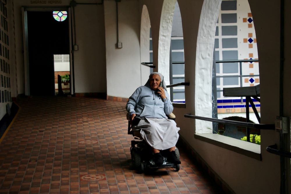 La Hna. Rosa Cadavid recibe una llamada silenciosa en el pasillo cubierto del Santuario de la Madre Laura, parte del recinto que considera su hogar. Diseñado por la primera santa canonizada de Colombia, el espacio ofrece paz y reflexión en los márgenes de una comunidad marcada por el conflicto. (Foto: Tracy L. Barnett)