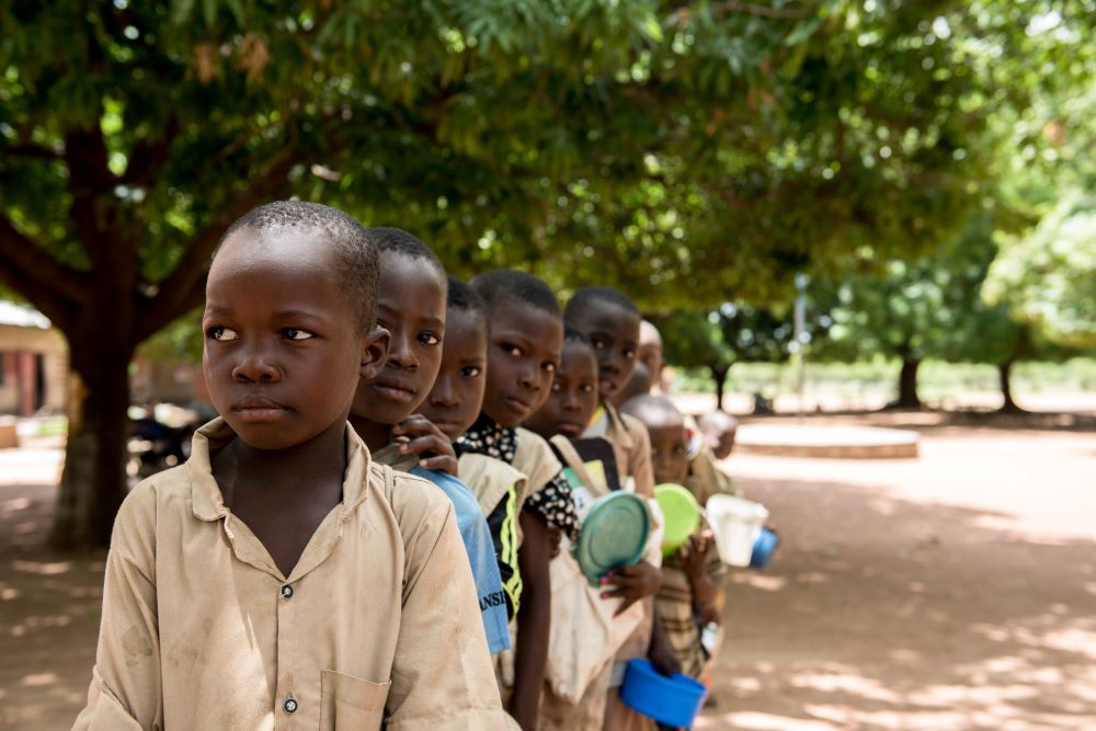 Students at a school in Kandi, Benin, line up for meals.