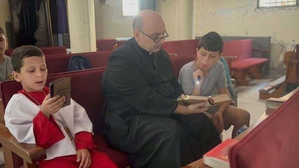 Fr. Gabriel Romanelli prays with parishioners. 