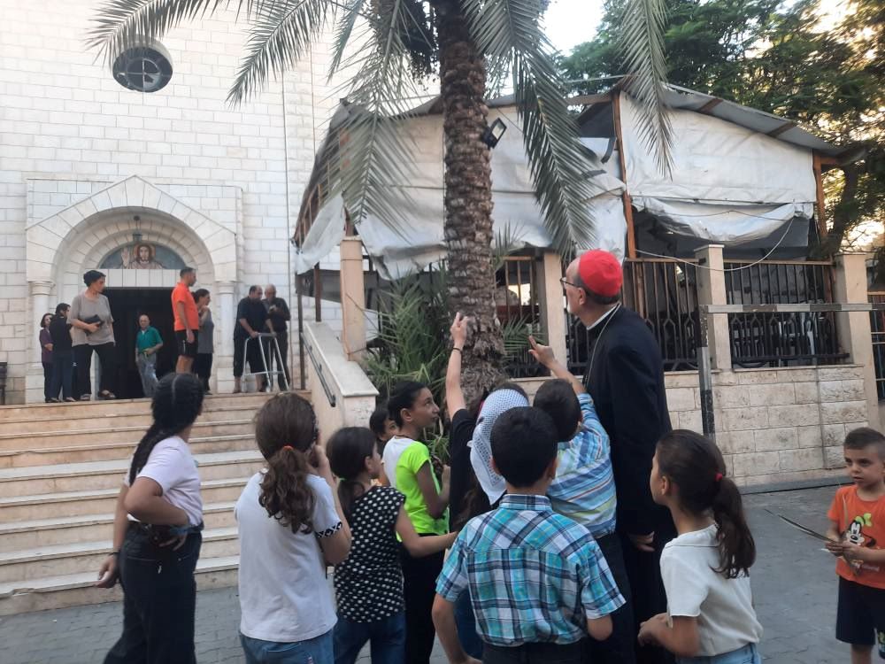 Palestinian Catholic children point out the top of Holy Family Catholic Church in Gaza City to Latin Patriarch Cardinal Pierbattista Pizzaballa. 