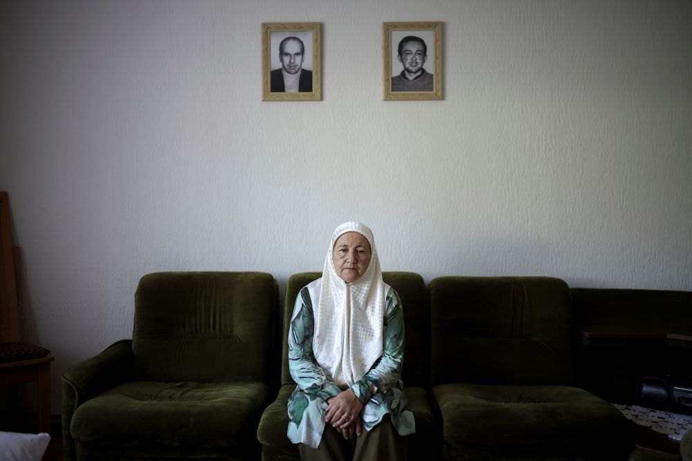 Fadila Efendic sits in her living room, with pictures of her son and husband on the wall behind her.  the village of Potocari near Srebrenica, Bosnia, on June 28. During the July 1995 genocide a total of 22 members of her family were killed. (AP/Armin Durgut)
