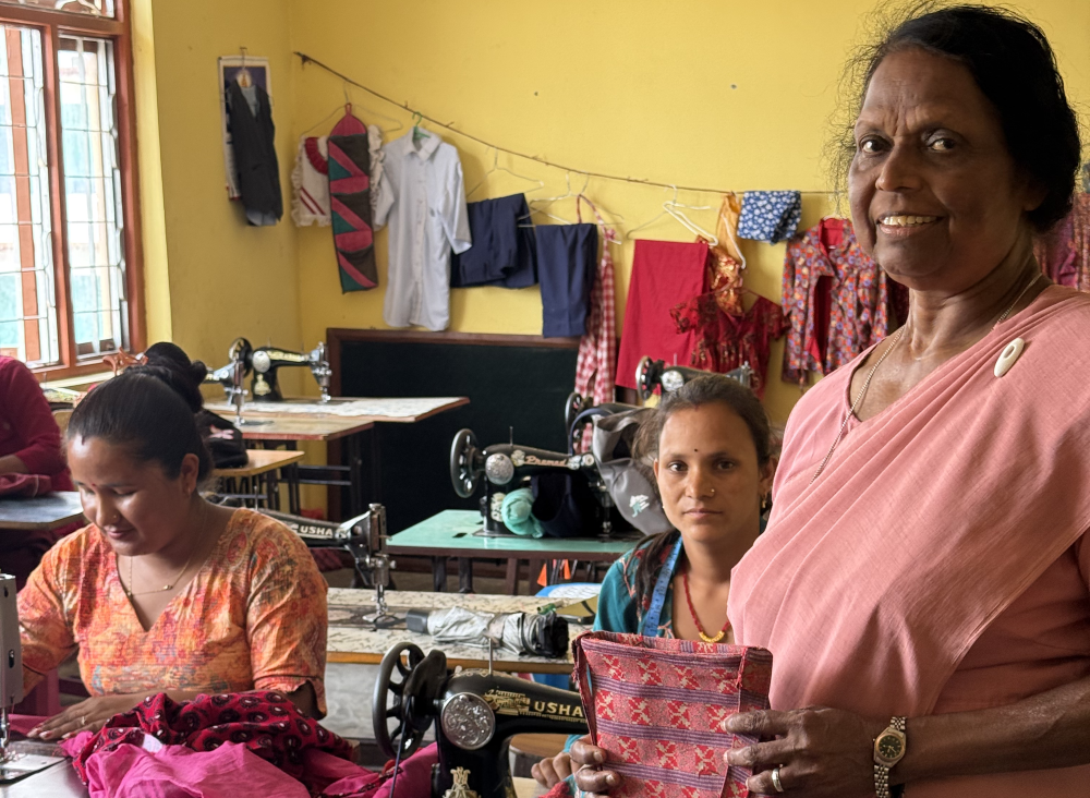 Sr. Rosita Kavilpurayidom poses with women participating in a tailoring training program.