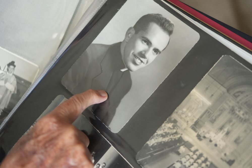 Fr. James Kelly points to a portrait of himself as a young priest in his photo album. Fr. James Kelly points to a portrait of himself as a young priest in his photo album.