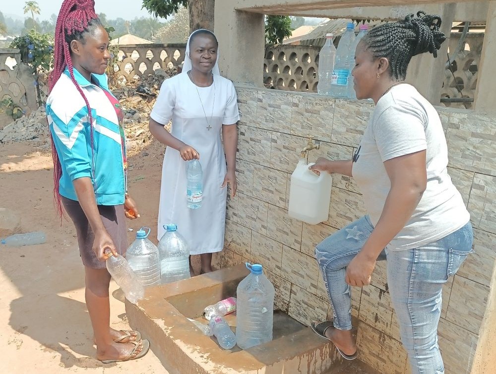Sr. Kum Shallotte near solar-powered borehole