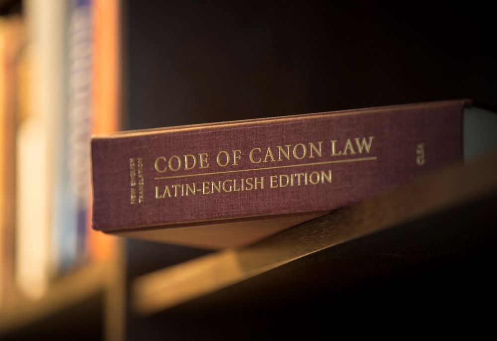 A Latin-English edition of the Catholic Church's Code of Canon Law is pictured on a bookshelf. 