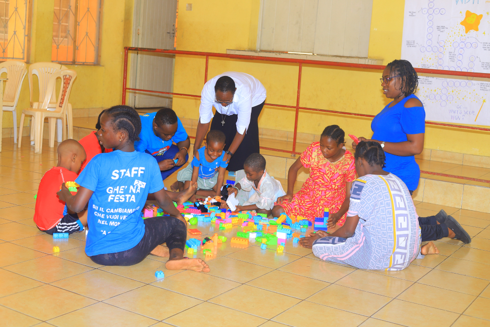 Children gather on the tiled floor for a group building activity led by caregivers and sisters.  (GSR photo/Doreen Ajiambo)