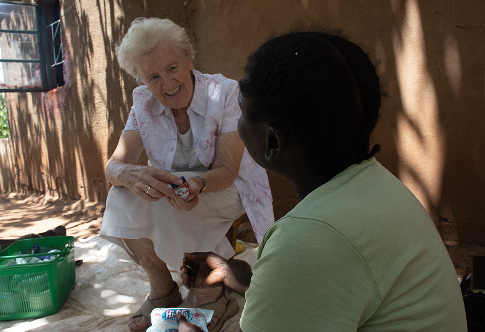 Sr. Mary Courtney visits a patient. Courtney is a member of the Franciscan Missionary Sisters for Africa. (Derrick Silimina)
