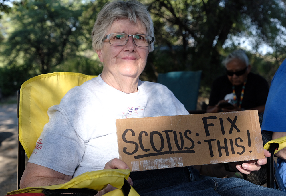Jane German, a co-member of the Loretto Community, holds a sign at Oak Flat demanding the Supreme Court to do justice by the Apache. (Courtesy of Steve Pavey)