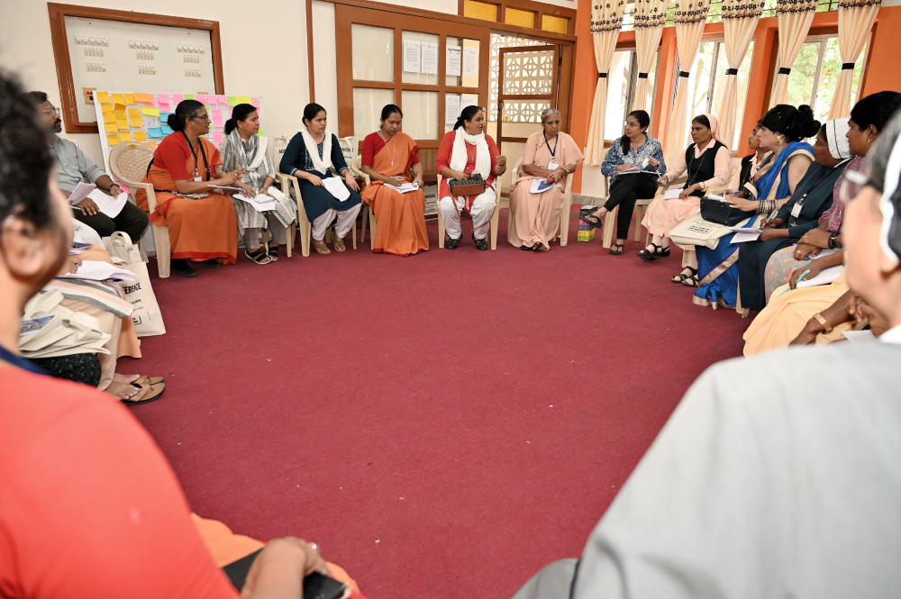 Women religious and transgender individuals engage in a group discussion. 