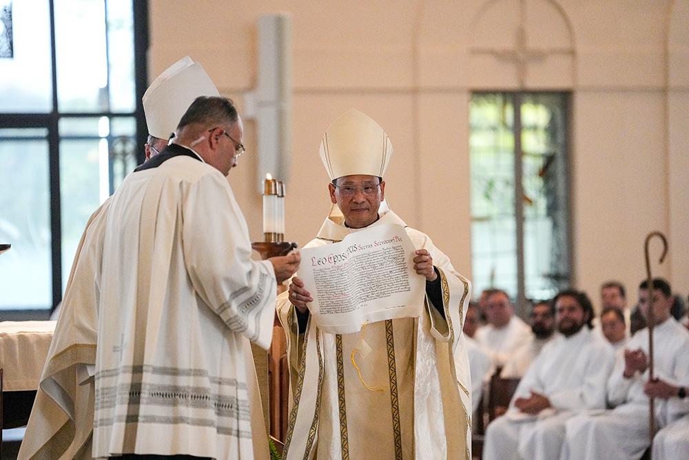 Bishop Michael Pham receives the apostolic mandate from Pope Leo XIV at the Mass installing him as head of the San Diego Diocese on July 17, 2025, at St. Thérèse of Carmel Parish in San Diego. (NCR photo/Chris Stone)