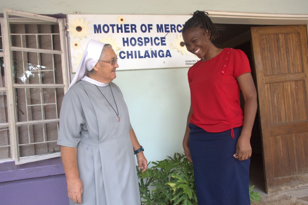 Sr. Jeremia Mrowiec and Esther Lungu talk outside hospice. 