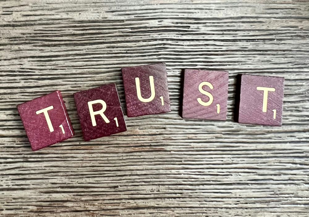 Scrabble tiles spell "trust."