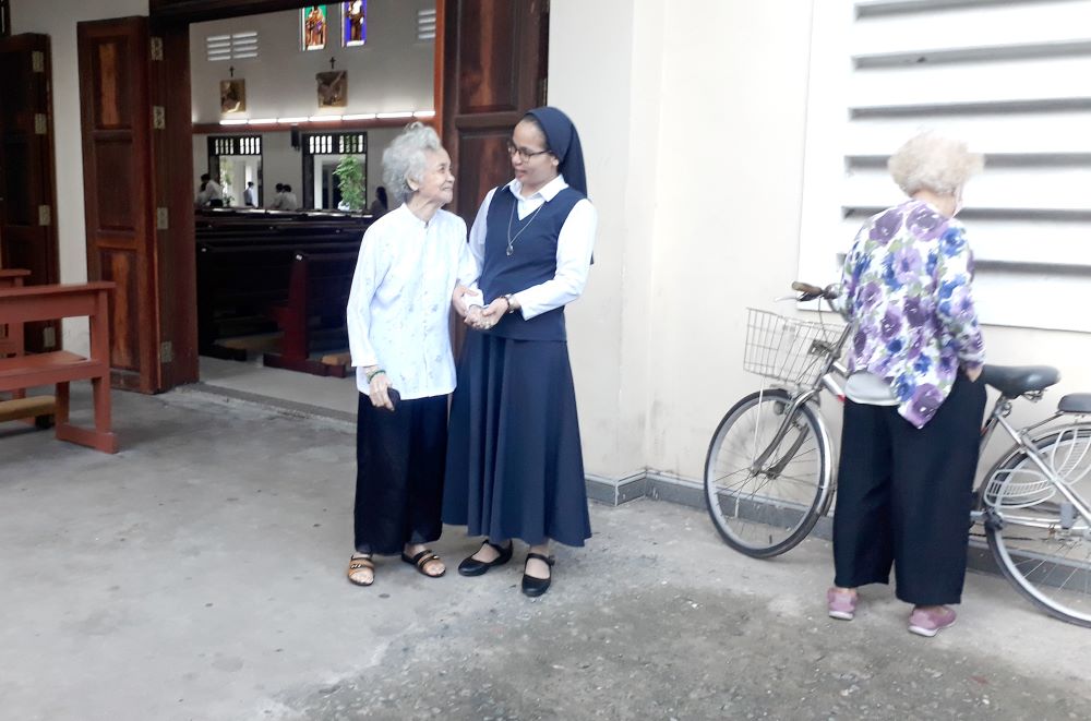 Sr. Anna Huynh Thi Dien talks with an elderly woman.