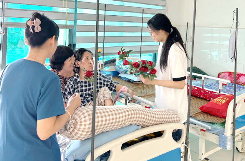 Sister hands roses to patient.