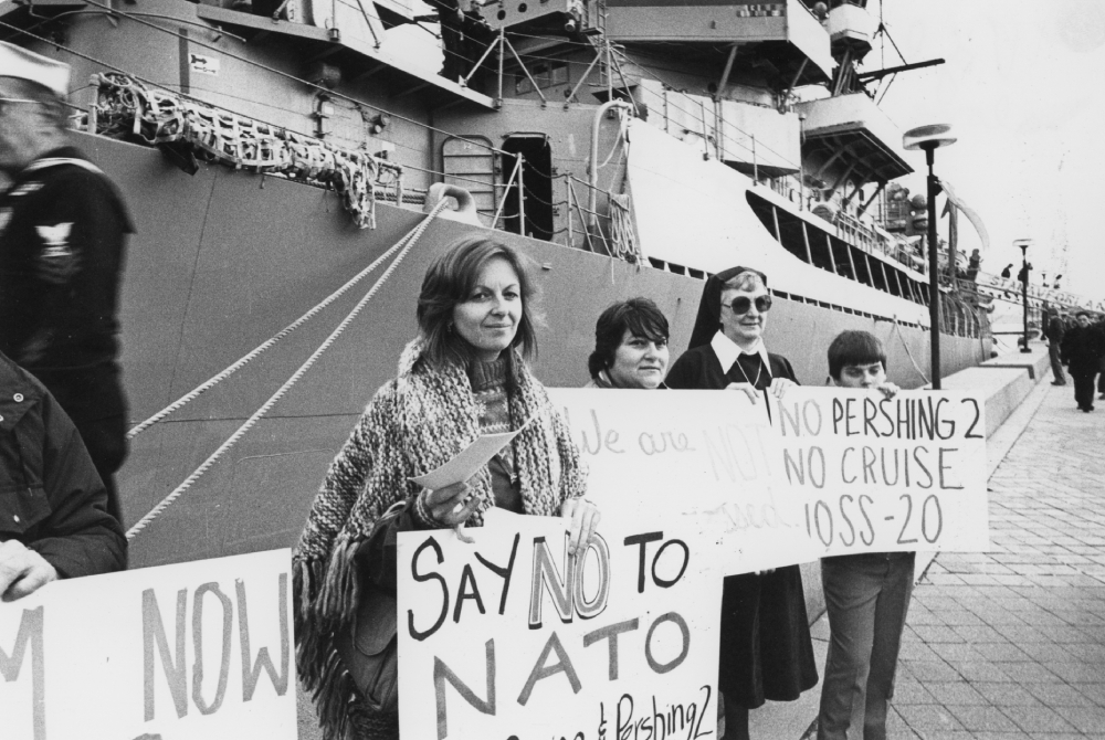 A sister in habit is seen among those holding a vigil against nuclear weapons on the pier alongside the guided-missile destroyer USS Dewey on Nov. 11, 1983. (NCR photo/Peter Wingert)