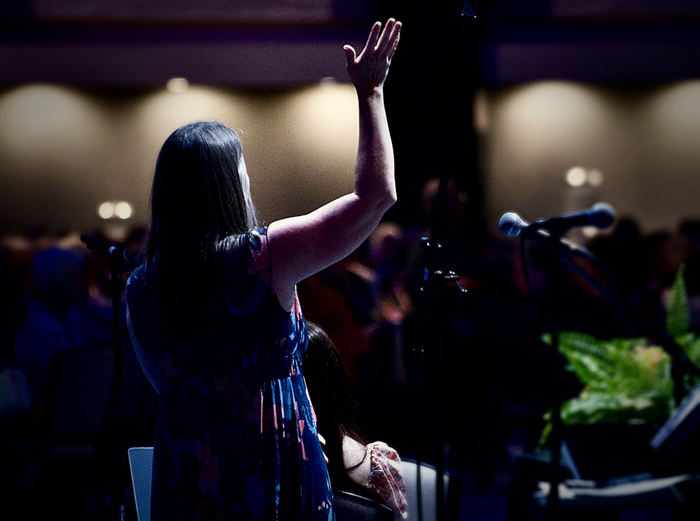 Julie Tragon, liturgist for the LCWR assembly, raises her hand in praise as CeCe Winans' song "Goodness of God" plays Aug. 15. (GSR photo/Dan Stockman)