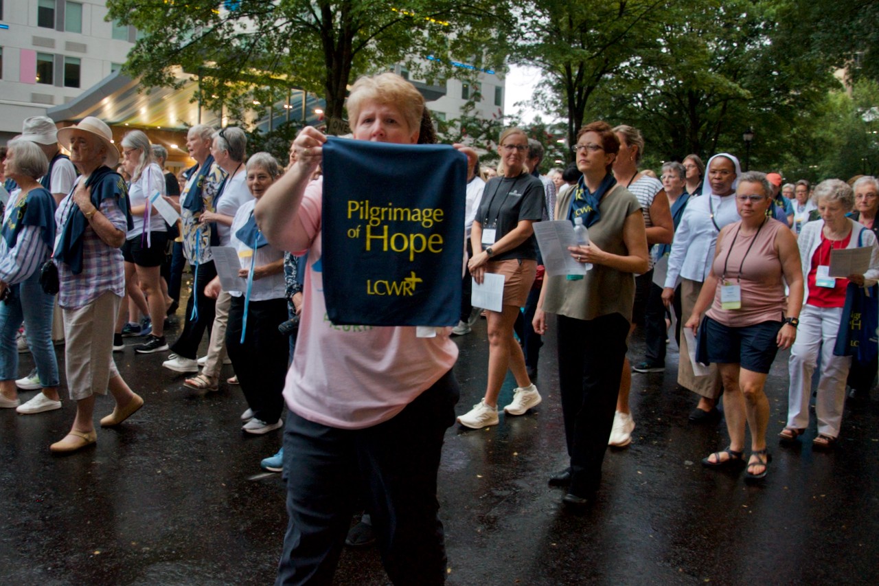 Una participante de la Peregrinación de la Esperanza sostiene un estandarte mientras cientos de hermanas católicas marchan por el centro de Atlanta, Estados Unidos, el 14 de agosto, en el marco de la asamblea anual de LCWR. (Foto: GSR/Dan Stockman)  