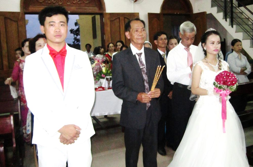 A young couple who completed a marriage catechism course with the St. Paul de Chartres sisters celebrate their wedding at Thanh Da Church in Hue on Aug. 21. (Joachim Pham)
