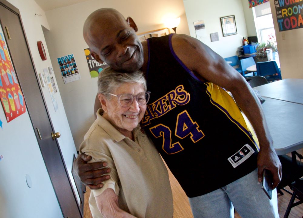 Sr. Julia Huiskamp gets a hug from resident Mike Devine, in the Thomas Terry Community Center. 