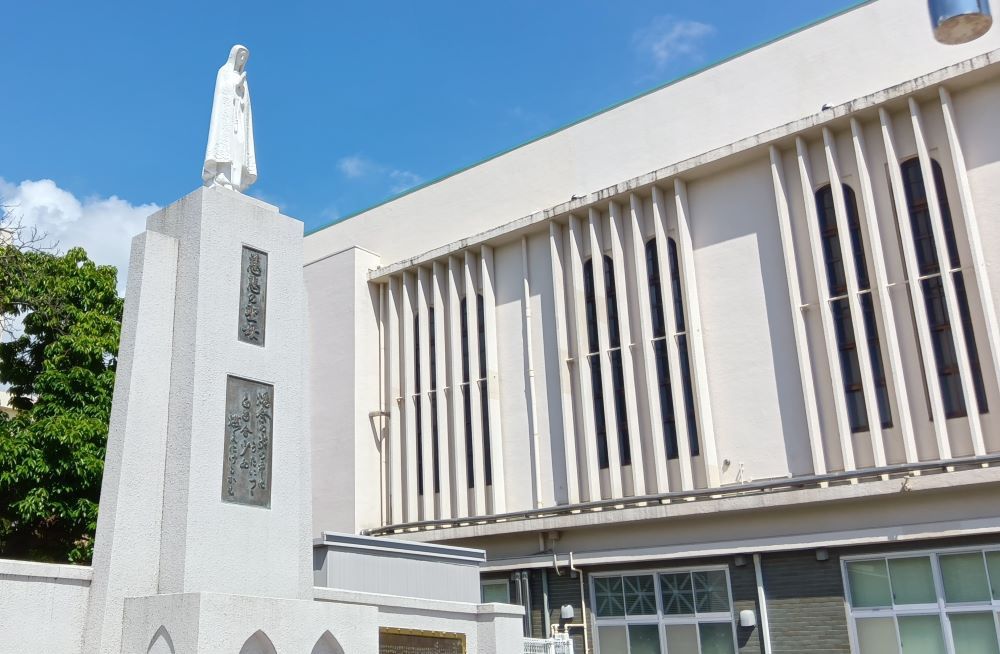 A white building with Our Lady of Mercy statue
