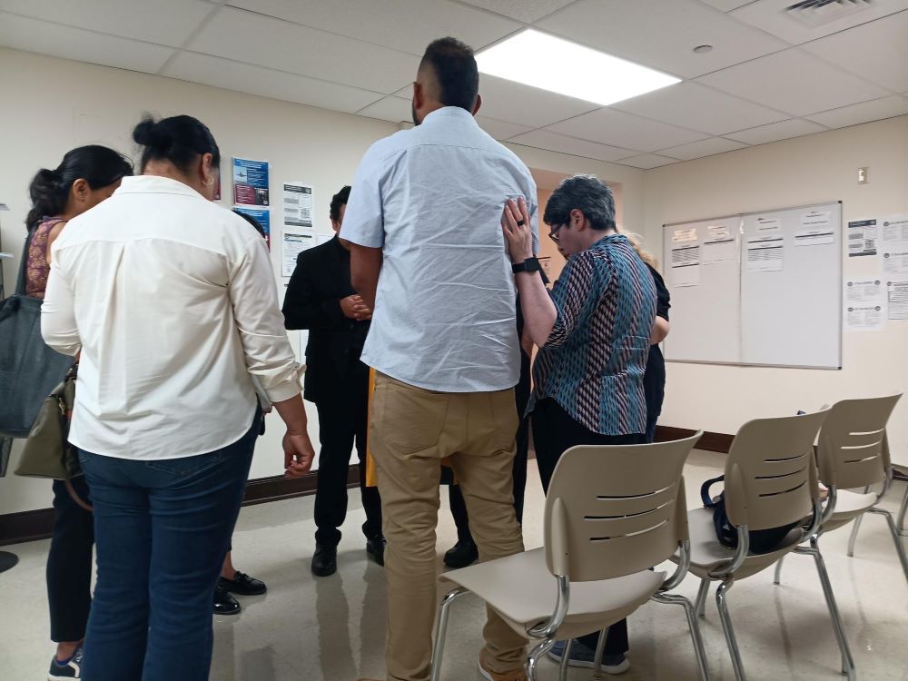 Sr. Leticia Gutiérrez Valderrama, right, and others pray with a man in a room at an immigration court in El Paso June 25. 