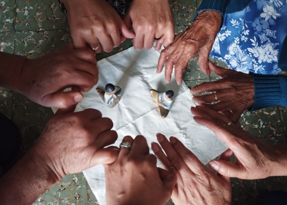 Hands of women from different generations symbolize their commitment to weave sisterhood together amid the violence in their neighborhood. (Flight in V Formation)