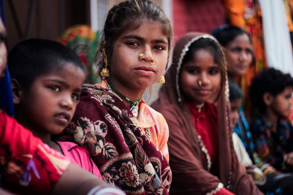 A row of girls sit together.