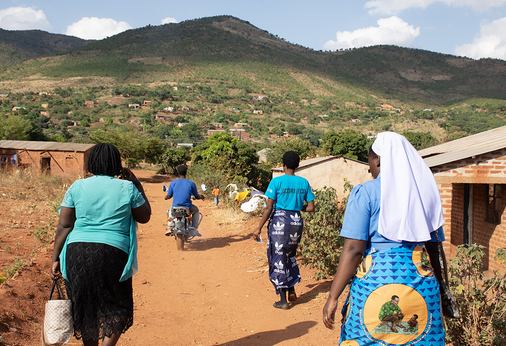 Sr. Christabel Kazembe and SCORE-ECD beneficiaries walk in the remotest parts of Chipata during a baseline assessment. (Derrick Silimina)
