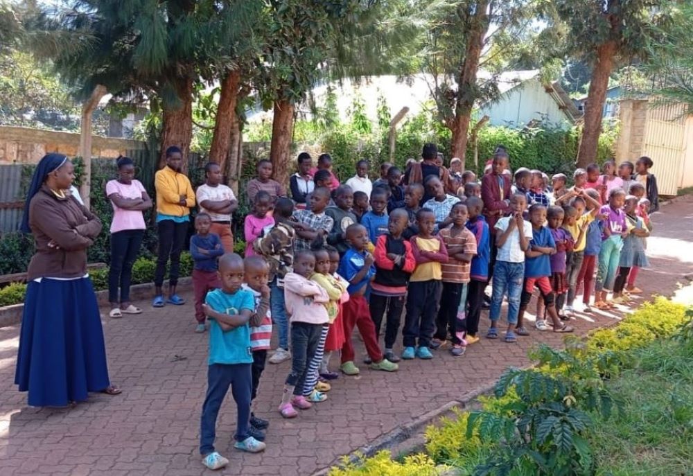 Sr. Justicia Nekesa stands with a group of children.