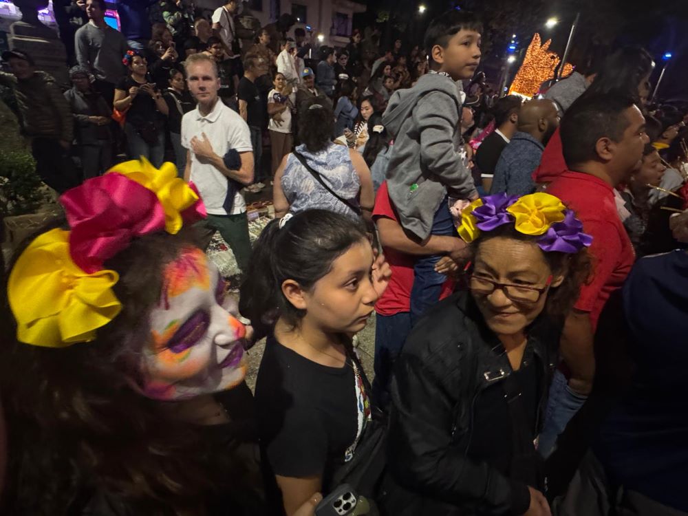 Un trío de mujeres se reúne el 25 de octubre de 2025 para ver el Desfile de las Catrinas, una representación de elegantes esqueletos, por el Paseo de la Reforma en la Ciudad de México. Millones de personas se reunieron para saludar y animar a los que representaban a los muertos, bailando, tirando dulces a la multitud y posando para fotos. (Foto: GSR/Rhina Guidos)