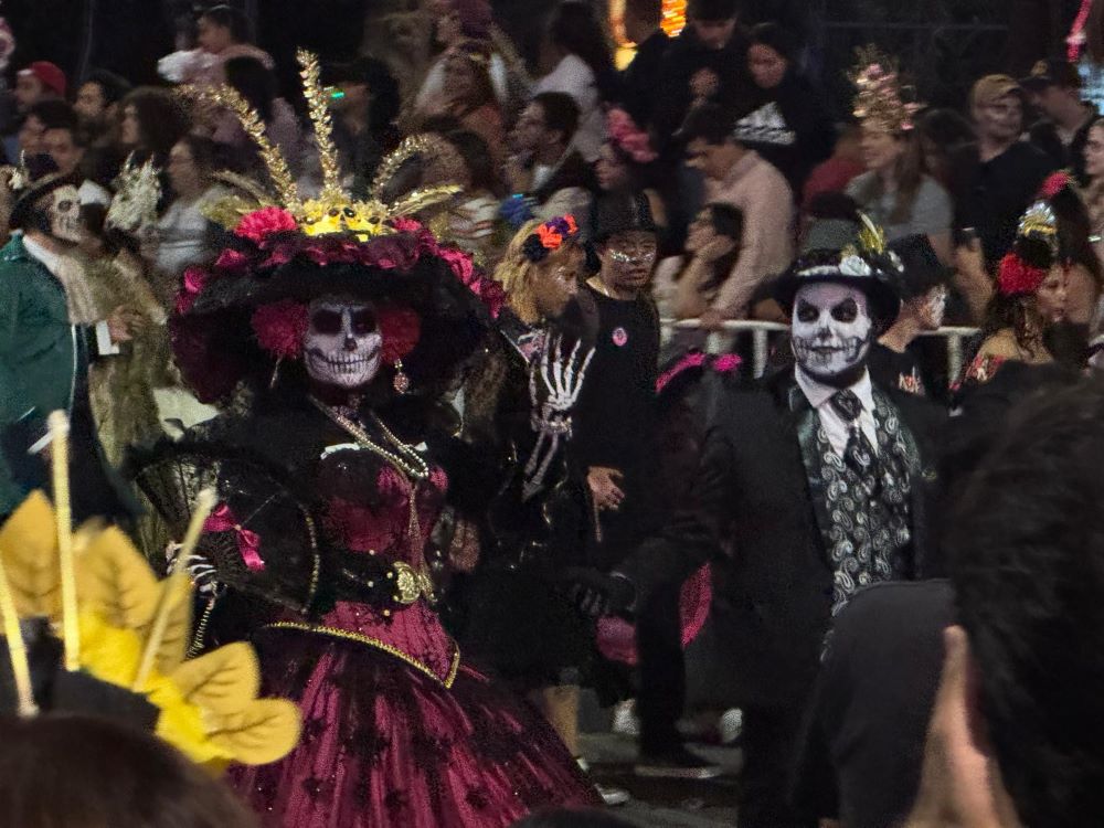 Una pareja camina por el Paseo de la Reforma en la Ciudad de México, el 25 de octubre de 2025, durante el Desfile de las Catrinas, elegantes representaciones de esqueletos. El desfile representa a los muertos casándose, tocando musica, bailando, pasándolo bien en otra existencia. (Foto: GSR/Rhina Guidos)