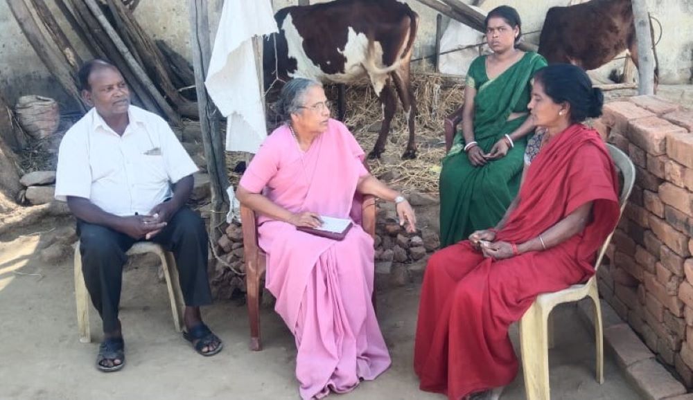 Sr. Rosily Kolencherry interacts with two women. 