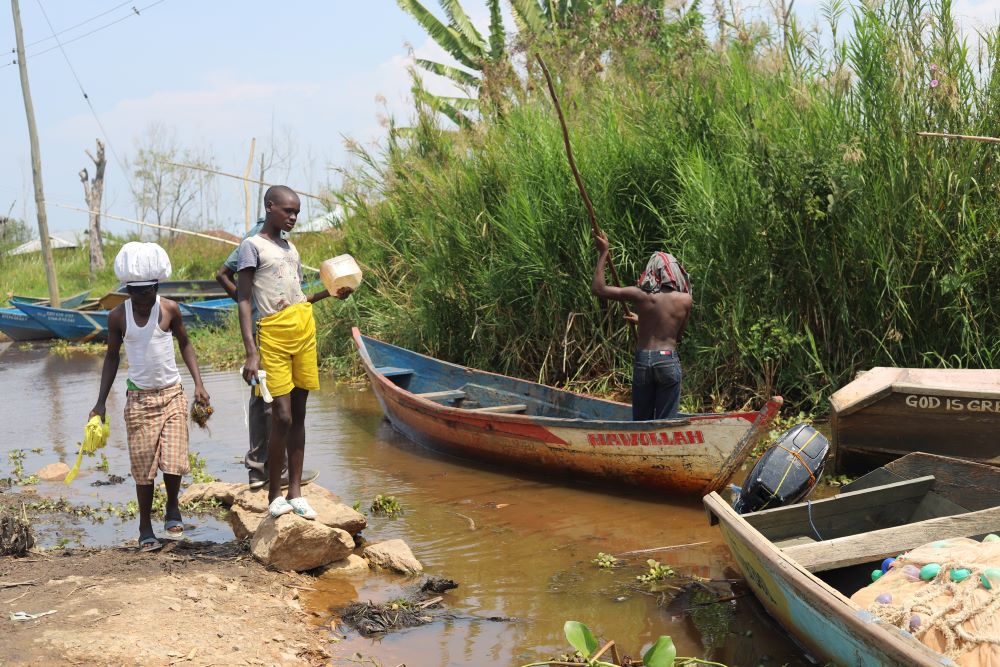Residents of Mau Mau village stand near flooded plots where they hope to plant bamboo to help prevent future floods. (Tonny Onyulo)