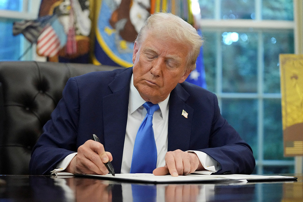 U.S. President Donald Trump signs an executive order in the Oval Office at the White House in Washington Sept. 19, 2025. Trump signed two executive orders, one to establish a visa program overseen by the secretary of commerce called the "Trump Gold Card" and one to introduce a $100,000 fee for H-1B visas. (OSV News/Retuers/Ken Cedeno)