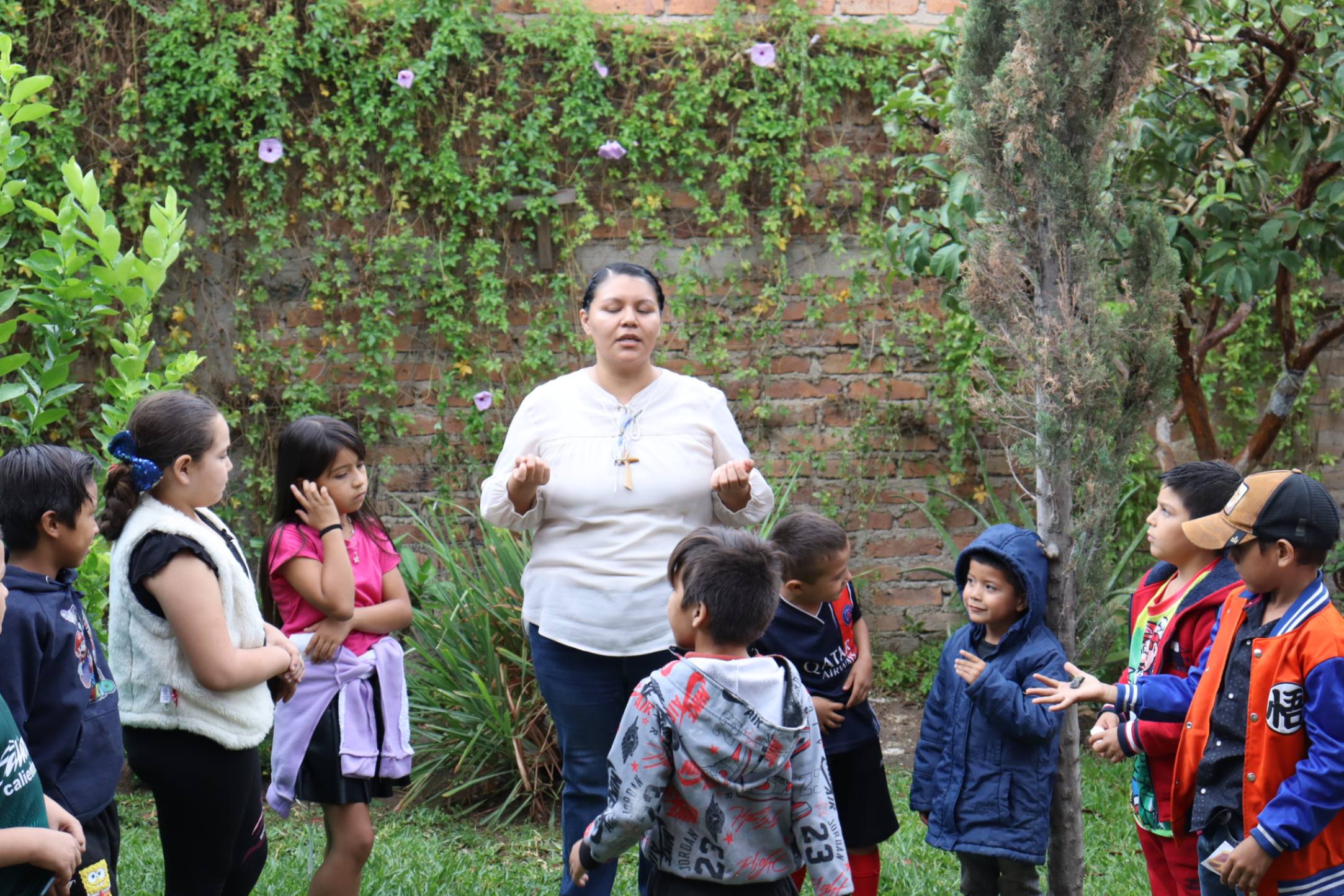 La Hna. Monserrat Mendoza y los niños oran en el jardín. La oración y reflexión personal forman parte de las actividades de preevangelización de A tu lado Kids, programa de la Compañía María de Nazareth. (Foto: Eduardo Cordero)