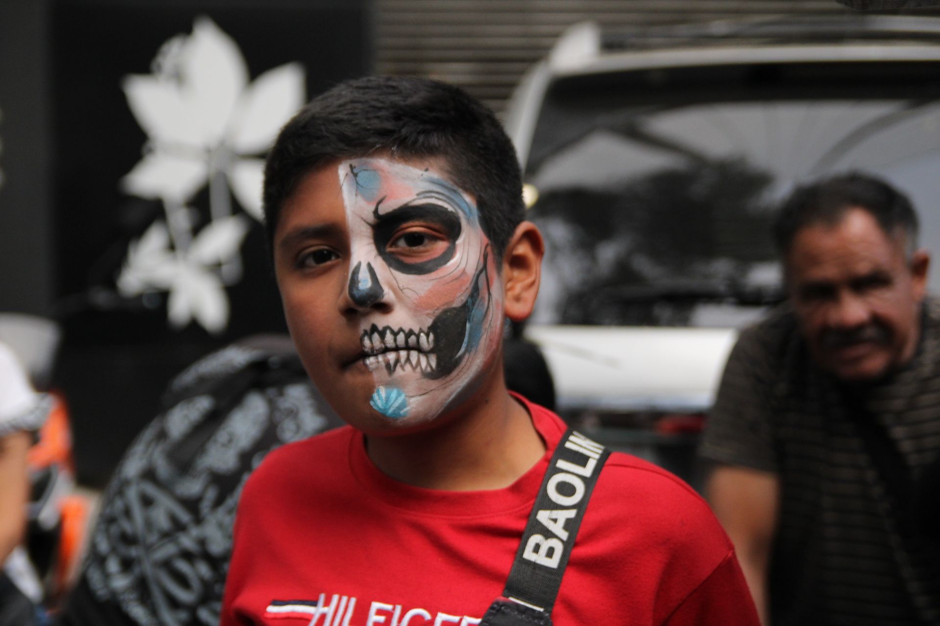 Un joven con la mitad del rostro pintado como catrina, representando la dualidad de vida y muerte, en el centro de la Ciudad de México, durante el Desfile de las Catrinas. (Foto: Helga Leija/GSR en español)