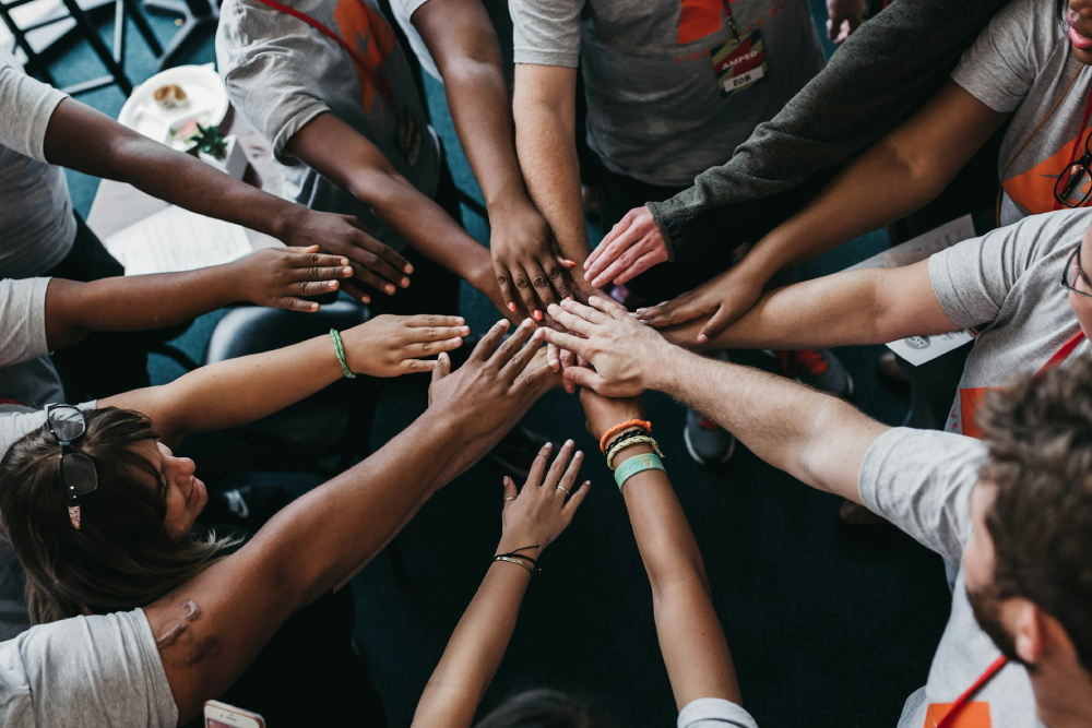 Hands meeting at the center of a huddle